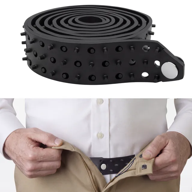 The Shirt Tucker, a black rubber belt coiled into a loop, with flex pegs along the strap and a metal button closure.