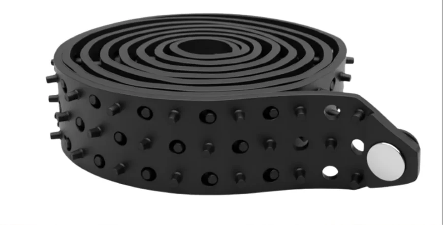 The Shirt Tucker rubber belt, coiled, showing the grip studs and the metal button